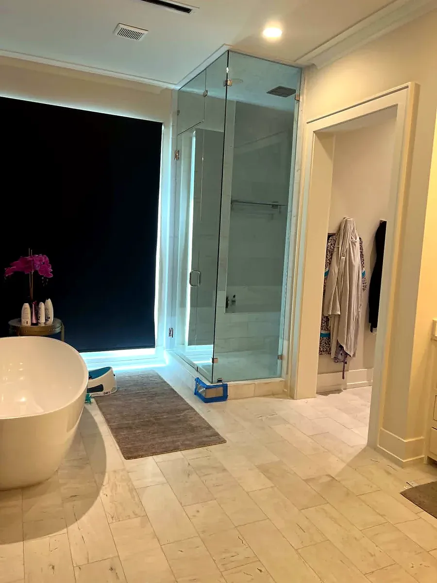 Primary bathroom with a freestanding tub and adjacent frameless glass shower