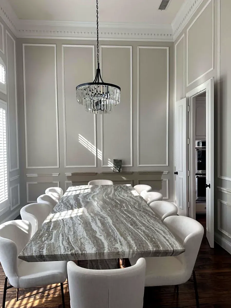 Dining room with floor to ceiling picture frame wall molding and a crystal chandelier
